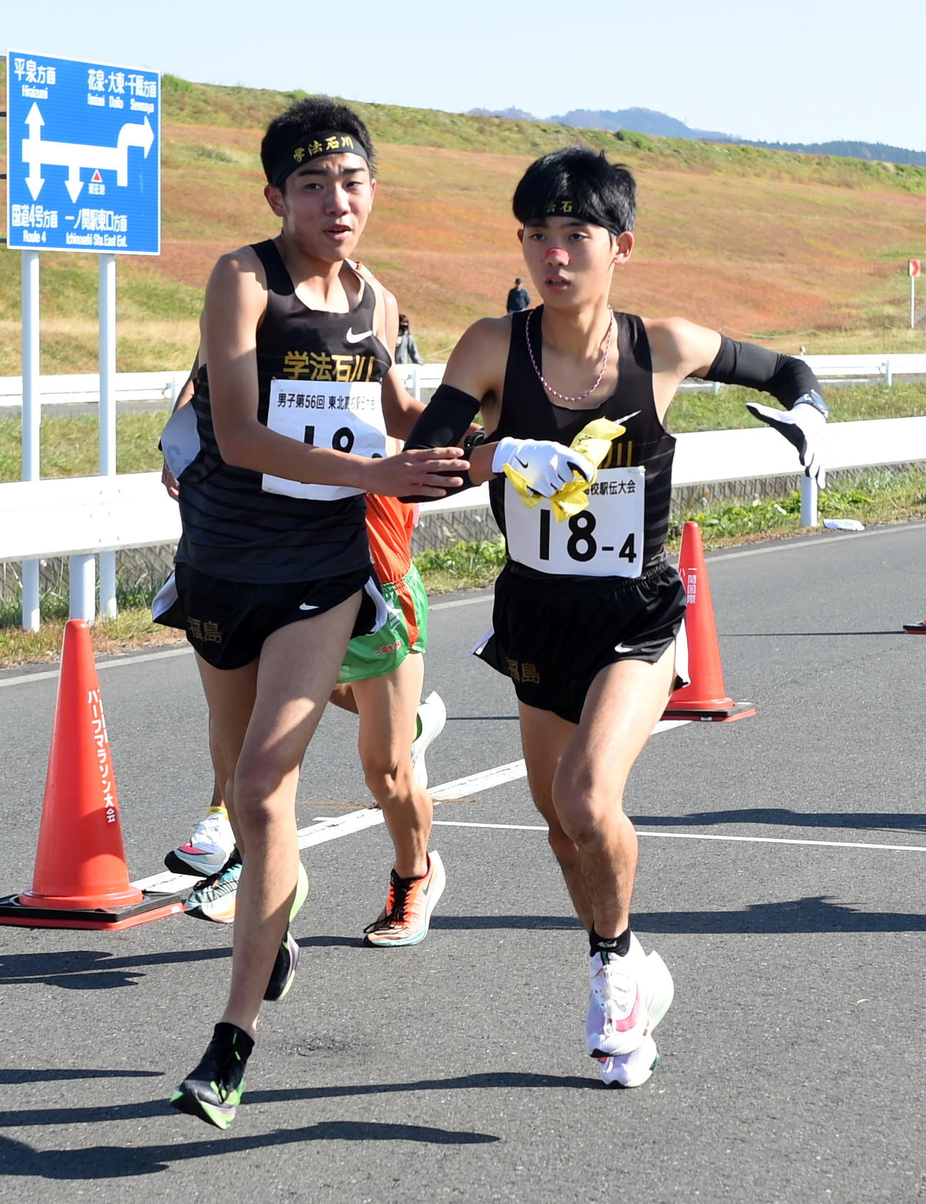 学法石川3区・山崎（左）からタスキを受け取る4区・小田切
