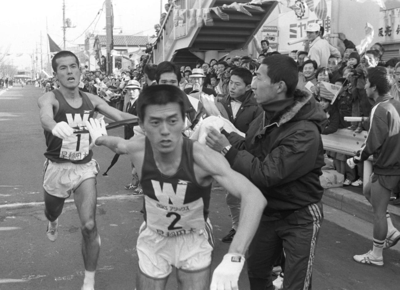 往路2区鶴見中継所　早大・石川海次（左＝4年）はトップで2区瀬古利彦（手前＝4年、区間新1時間11分37秒）にタスキを渡す　　※瀬古これまでの箱根駅伝＝すべて2区77年11位、78年2位、79年区間新＝1980年1月2日