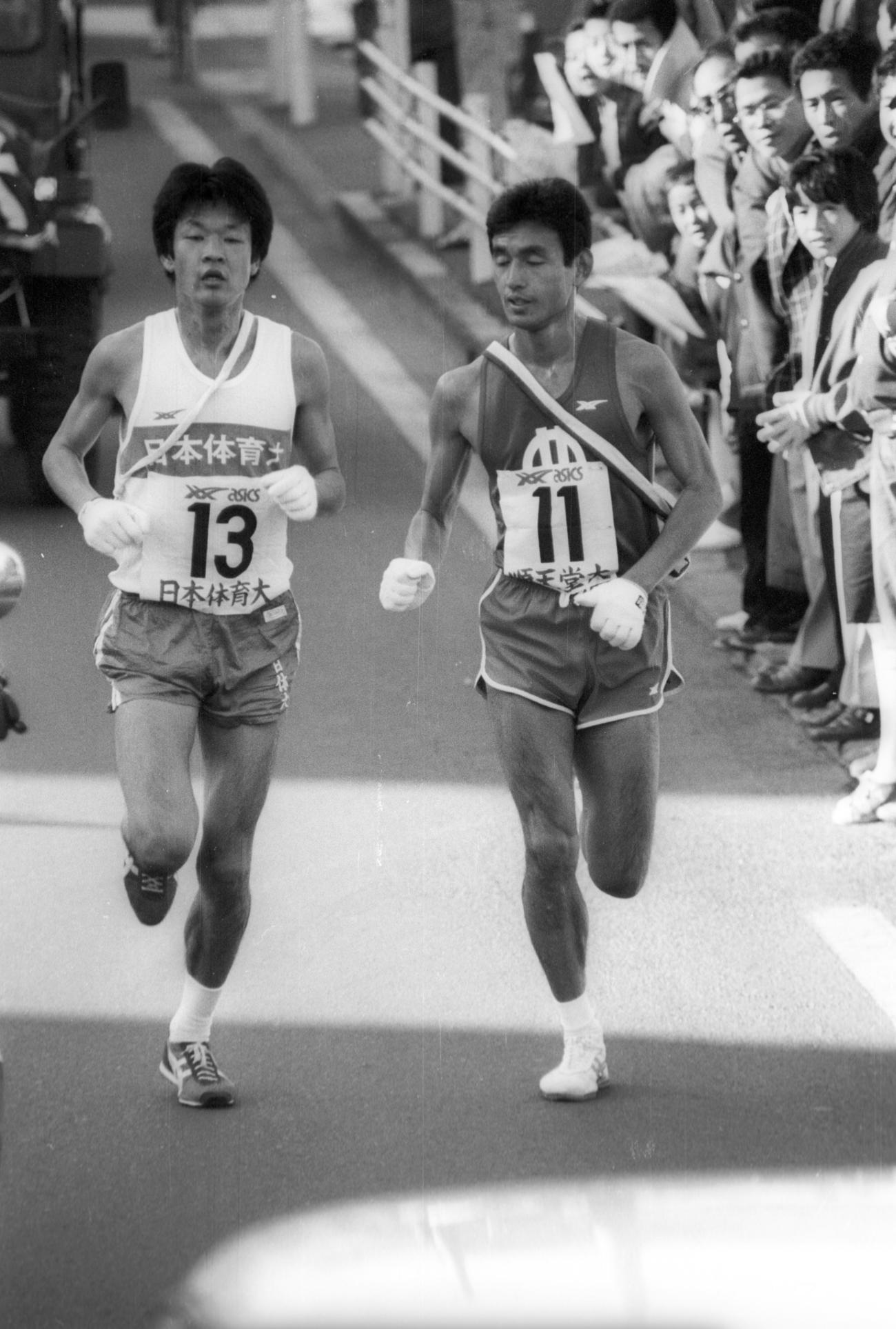 復路7区　6区谷口浩美が34秒差まで縮めた日体大は、7区前田直樹（左＝3年、区間1位）が酒匂橋手前の6キロ地点で、順天堂大・村松学（右＝4年、区間2位）をとらえ抜き去る＝1981年1月3日