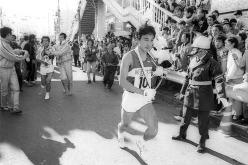復路10区鶴見中継所　トップを死守しアンカー小山輝夫（手前＝3年、区間新1時間05分51秒）にタスキを渡した順天堂大・神田修（後方＝3年、区間4位）＝1981年1月3日