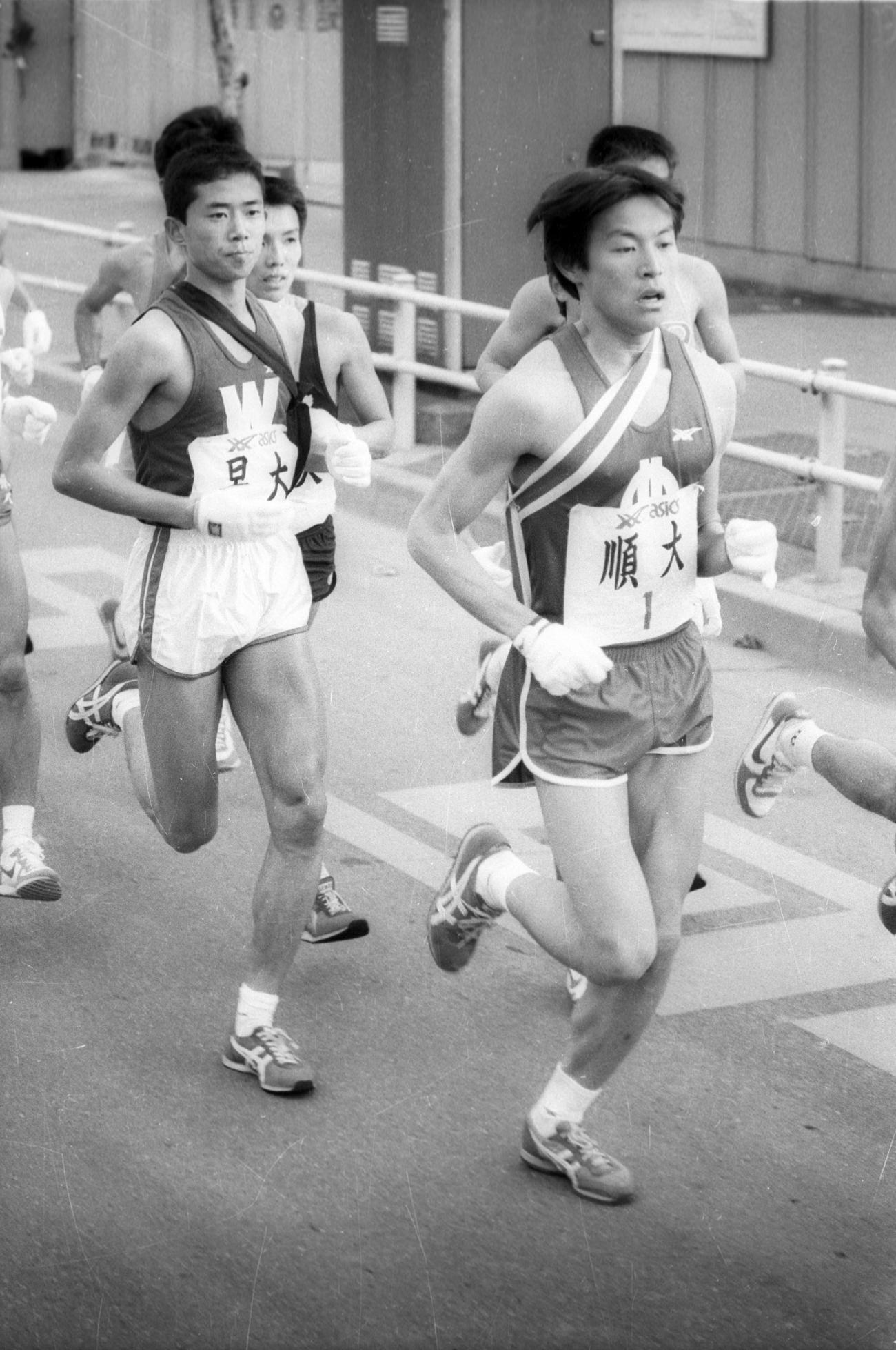 往路1区　順天堂大・岩佐吉章（右＝2年、区間6位）と早大・田原貴之（左＝2年、区間5位）＝1984年1月2日