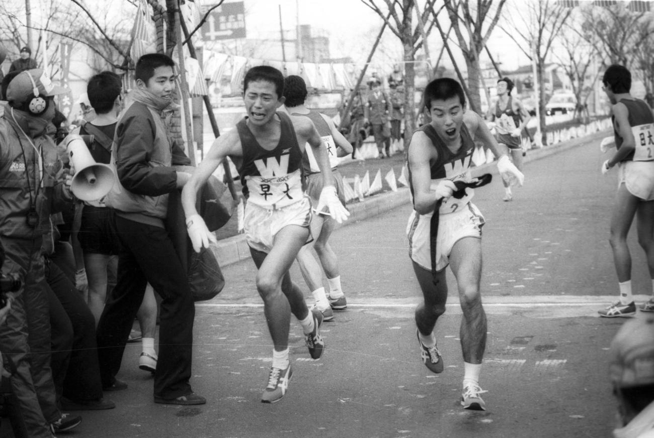 往路2区鶴見中継所　5位でタスキリレーする早大1区田原貴之（左＝2年）と2区坂口泰（右＝4年、区間2位）＝1984年1月2日