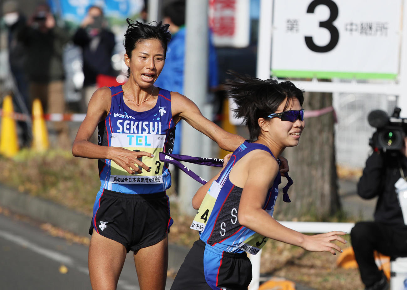 第40回全日本実業団対抗女子駅伝（クイーンズ駅伝）　積水化学の4区木村梨七（右）にトップでたすきをつなぐ3区新谷仁美（代表撮影）
