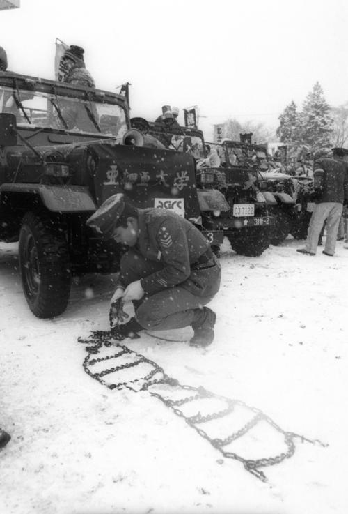 復路6区　7年ぶりの雪で急きょチェーンをつける亜大の伴走車＝1985年1月3日