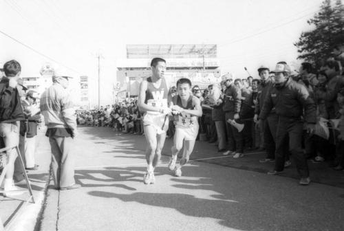 往路3区戸塚中継所　2位に1分21秒差をつけ3区坂内敦（右＝1年、区間5位）にトップでタスキを渡す早大・遠藤司（左＝4年、区間2位）＝1985年1月2日