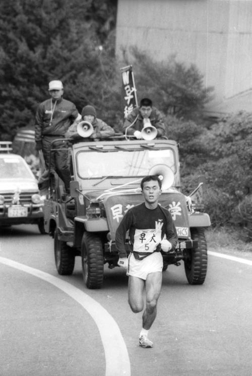 往路5区　伴走車に乗った遠藤司（中央＝4年、2区2位）の声援を受けながら3度目の箱根の山を快走、1時間11分59秒の区間新で首位を堅守した早大・木下哲彦（3年）＝1985年1月2日