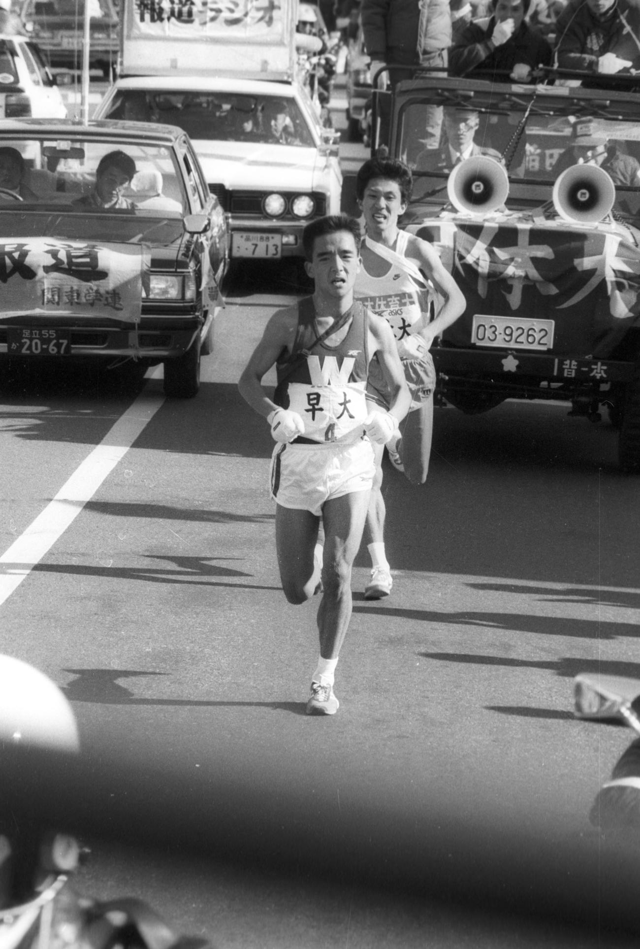 往路4区　日体大・丸山一徳（後方＝4年、区間2位）をとらえ、4位からついにトップに立った早大・豊福嘉弘（3年、区間1位）＝1986年1月2日