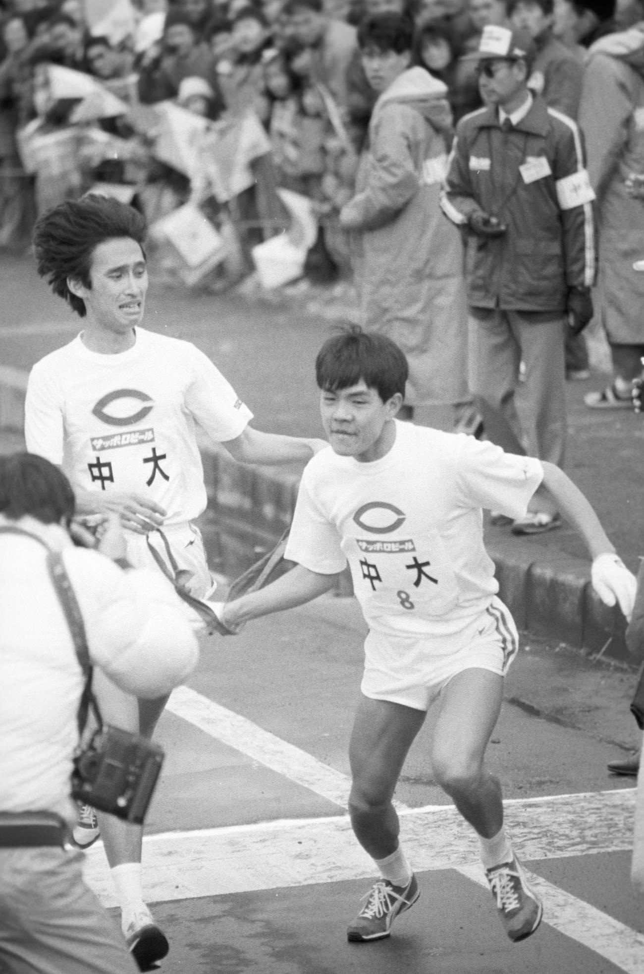 復路8区平塚中継所　トップを死守してタスキリレーする中大7区宮岡聖次（左＝4年、区間3位）と8区長谷川真也（右＝1年、4位）＝1987年1月3日