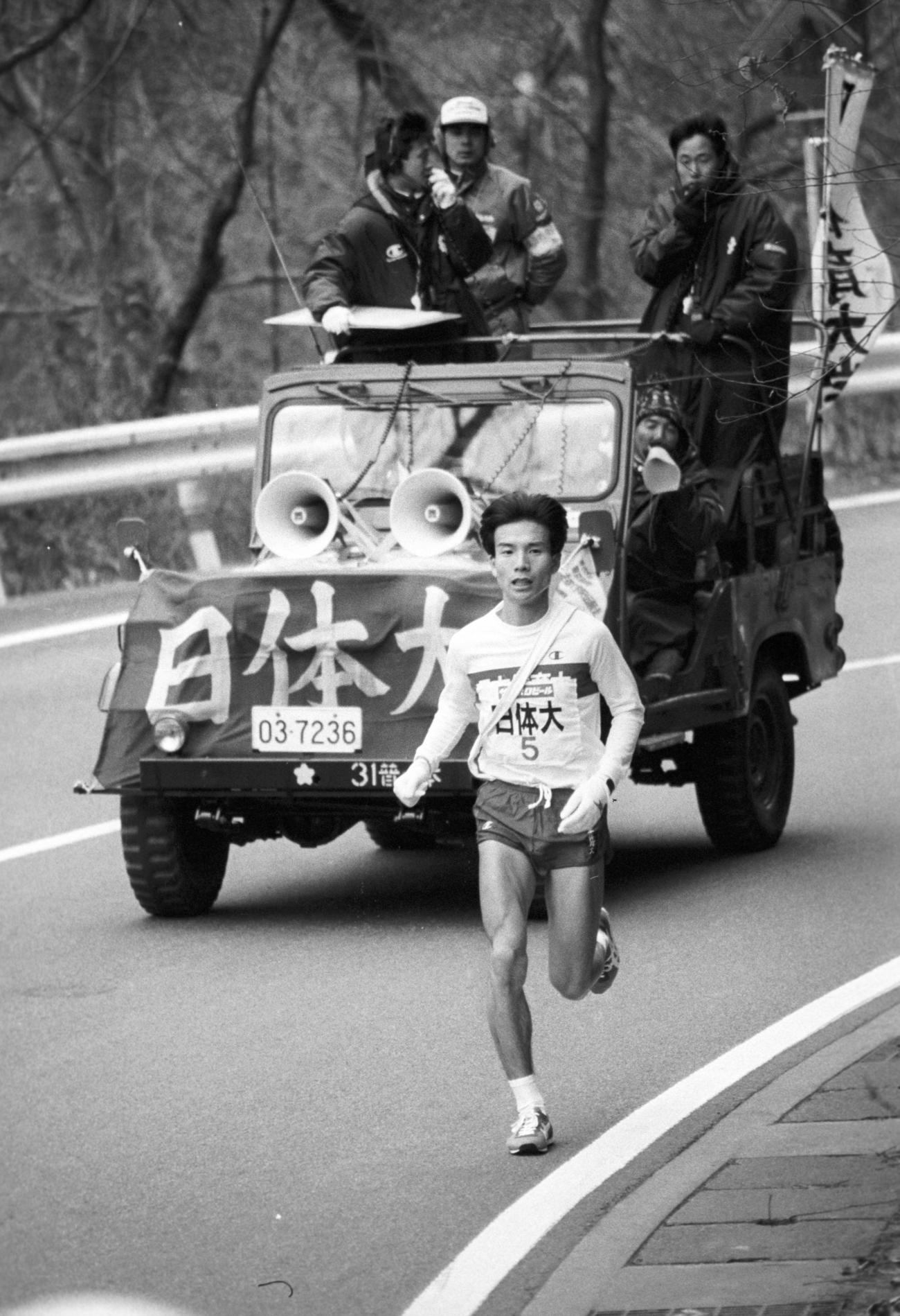 往路5区　トップを行く日体大・平山征志（3年、区間1位）、伴走車右端から激励するのは肉離れで出場できなくなった仲西浩主将＝1987年1月2日