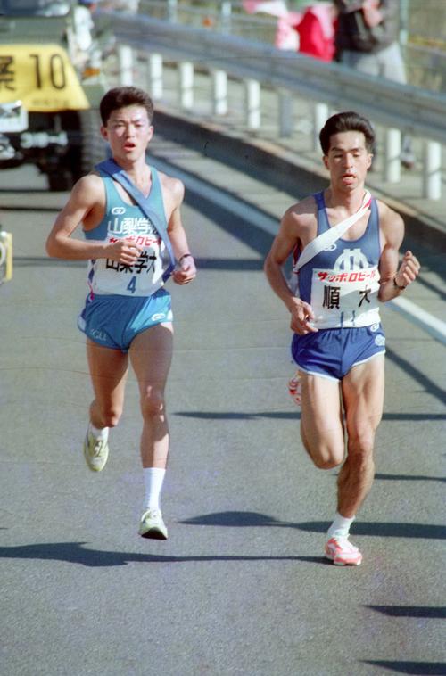 往路4区　順天堂大・倉林俊彰（右＝4年、区間1位）がついに山梨学院大・伊東宣明（左＝4年、区間6位）をとらえ、トップに出る＝1989年1月2日