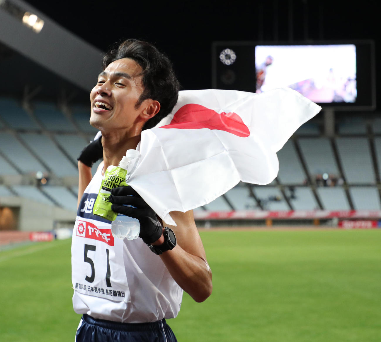 男子1万メートル　1位で五輪代表が内定し日の丸を掲げる相沢晃（撮影・清水貴仁）