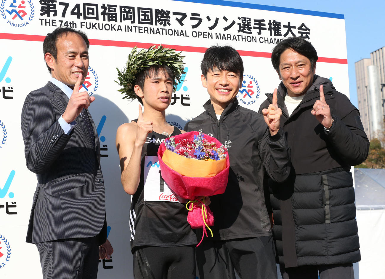 表彰台でポーズをとる、左から花田監督、吉田、熊谷GMO会長、原アドバイザー（撮影・梅根麻紀）