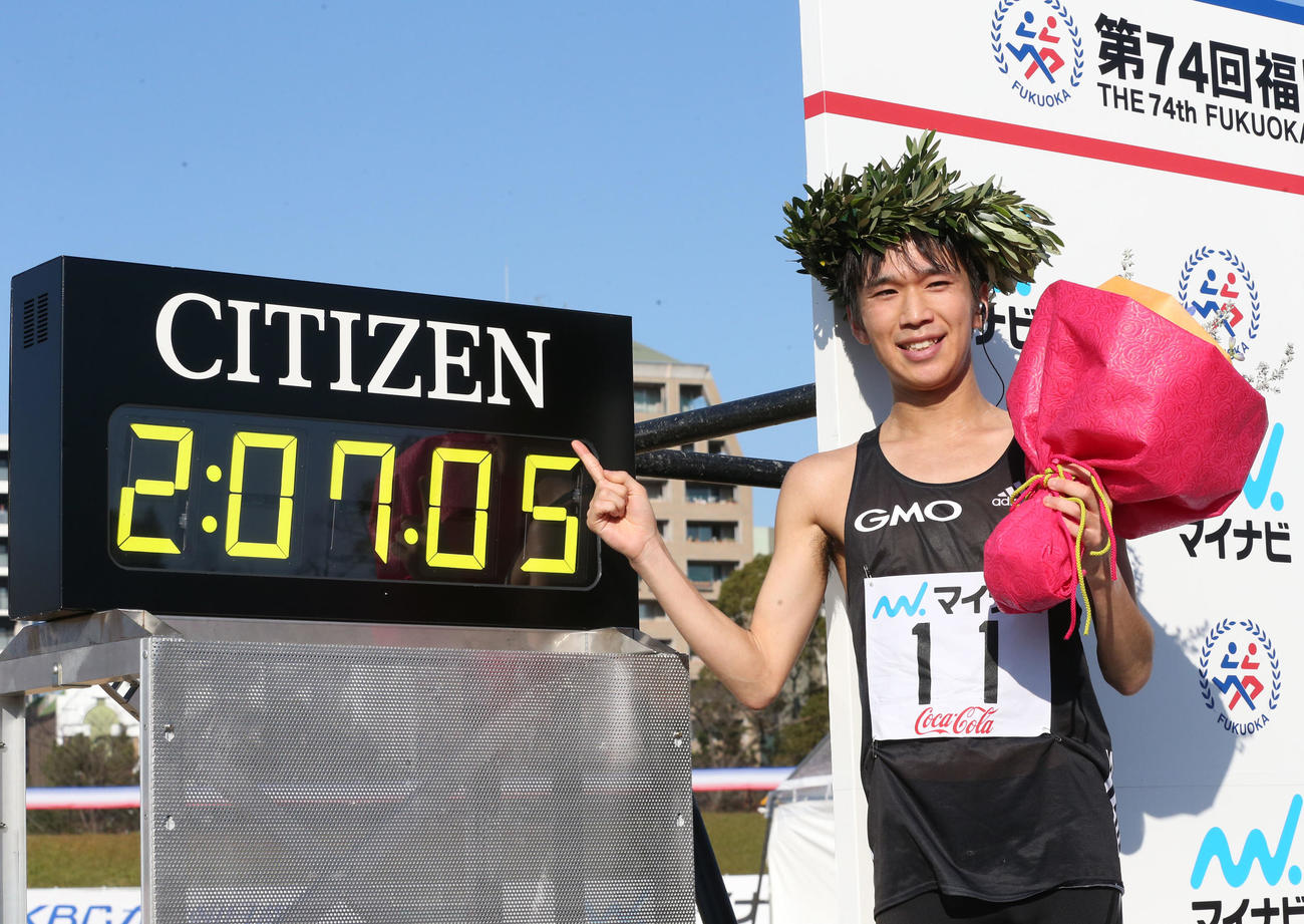 福岡国際マラソンで初優勝し笑顔で記念写真に納まる吉田（撮影・梅根麻紀）