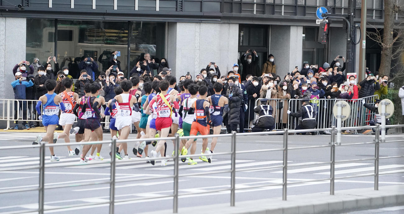 一斉にスタートする1区の選手たちを見守る沿道の人々（撮影・菅敏）