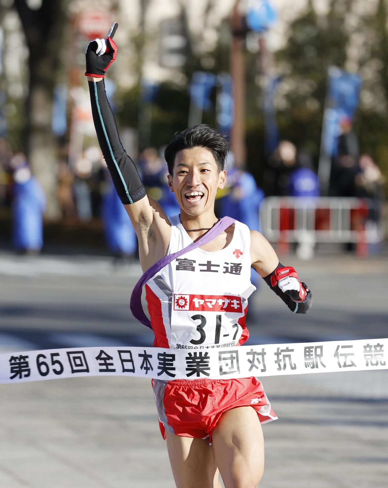 12年ぶり3度目の優勝を決め、指を突き上げる富士通のアンカー・浦野雄平（共同）