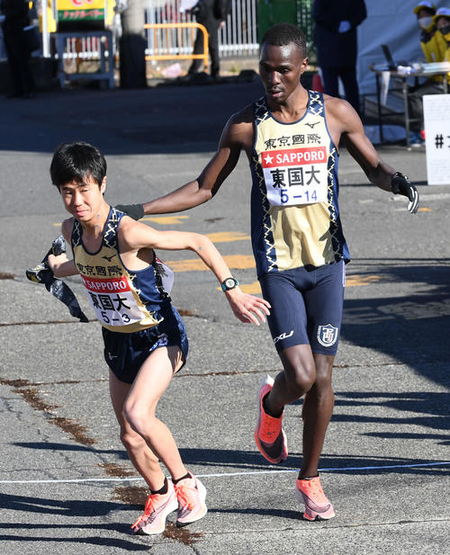 戸塚中継所にトップで駆け込んだ東京国際大2区ヴィンセントは3区内田にたすきを渡す（撮影・山崎安昭）