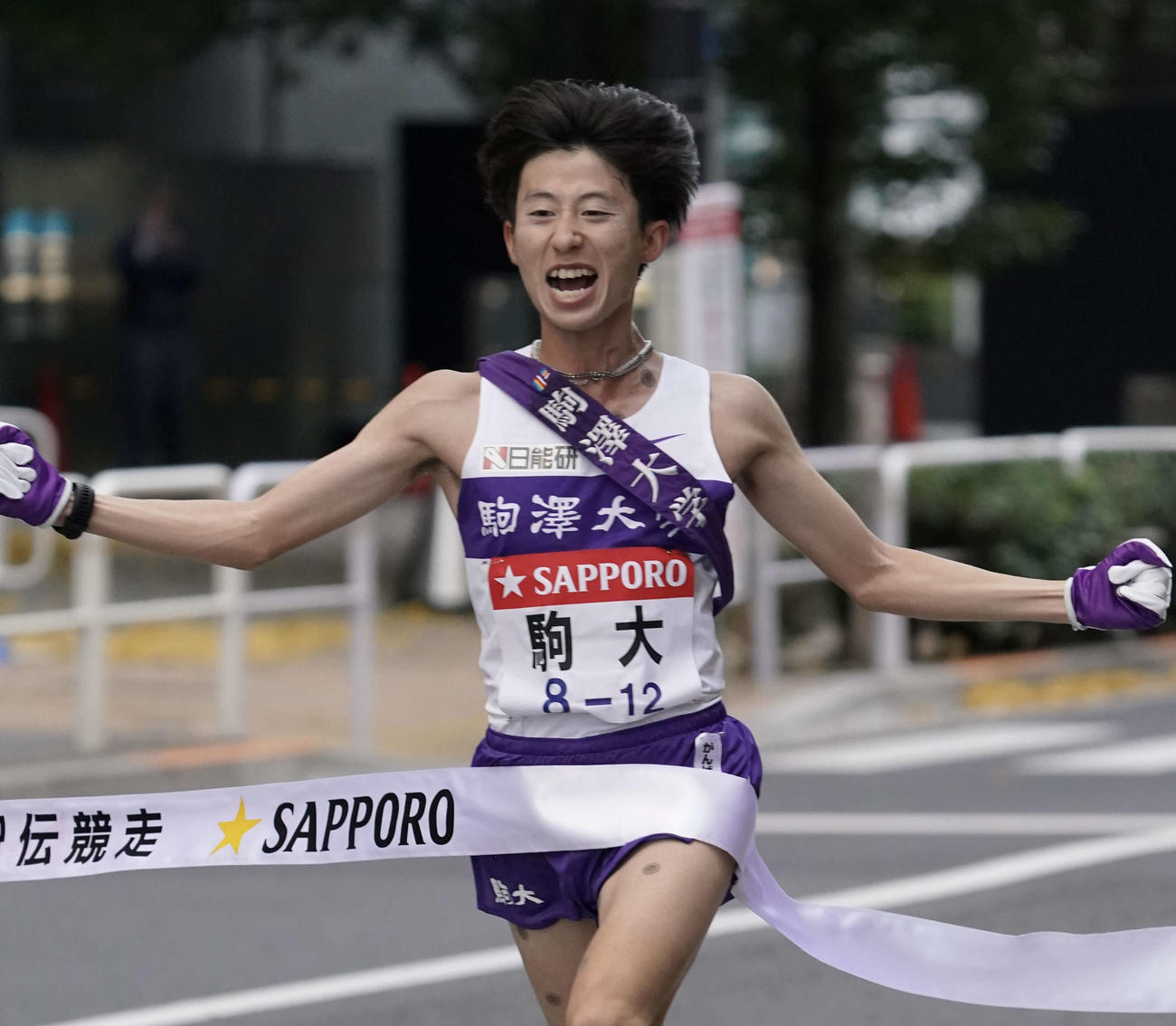 総合優勝し、ゴールテープを切る駒大10区石川（撮影・菅敏）