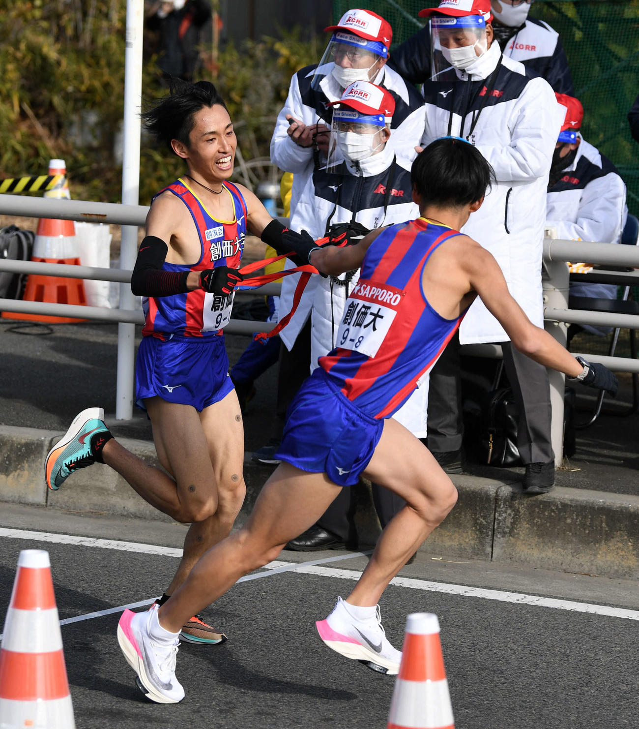 平塚中継所、トップでタスキをつなぐ創価大7区原富（左）と8区永井（撮影・横山健太）
