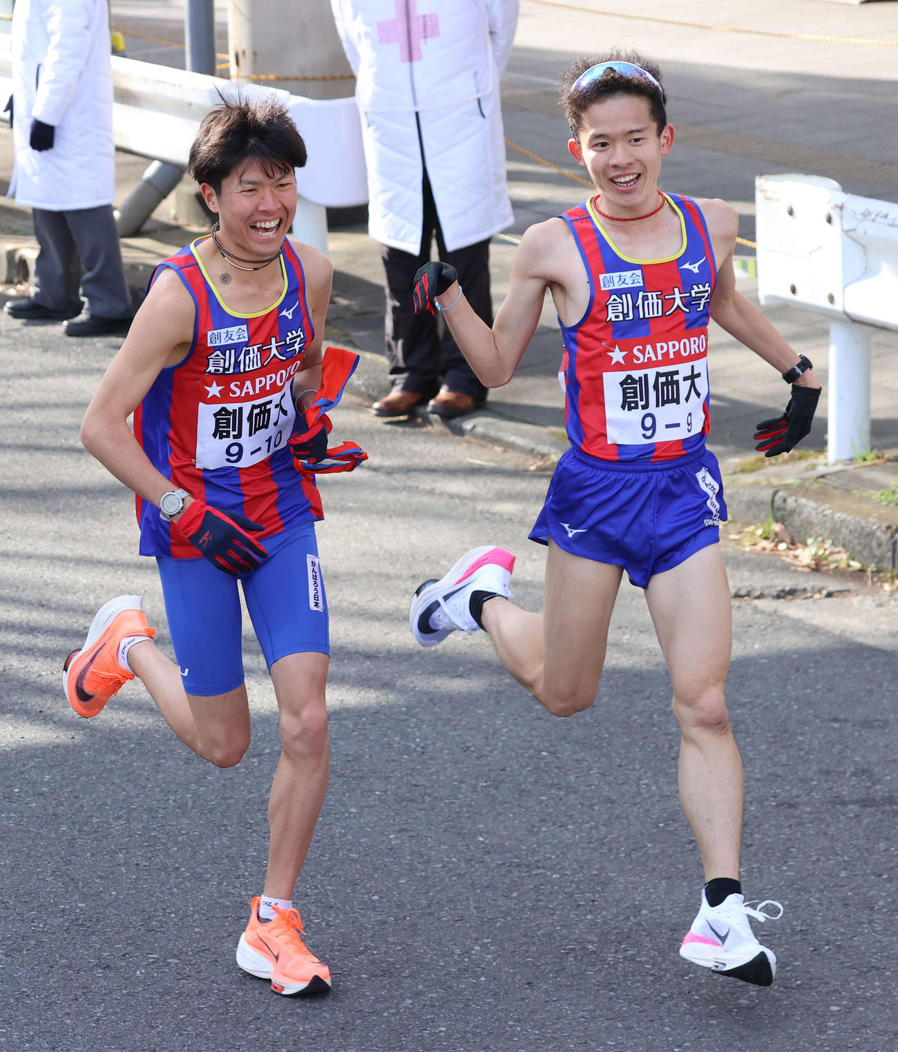 鶴見中継所、創価大9区石津（右）からタスキを受けて笑顔でスタートする10区小野寺（撮影・河野匠）