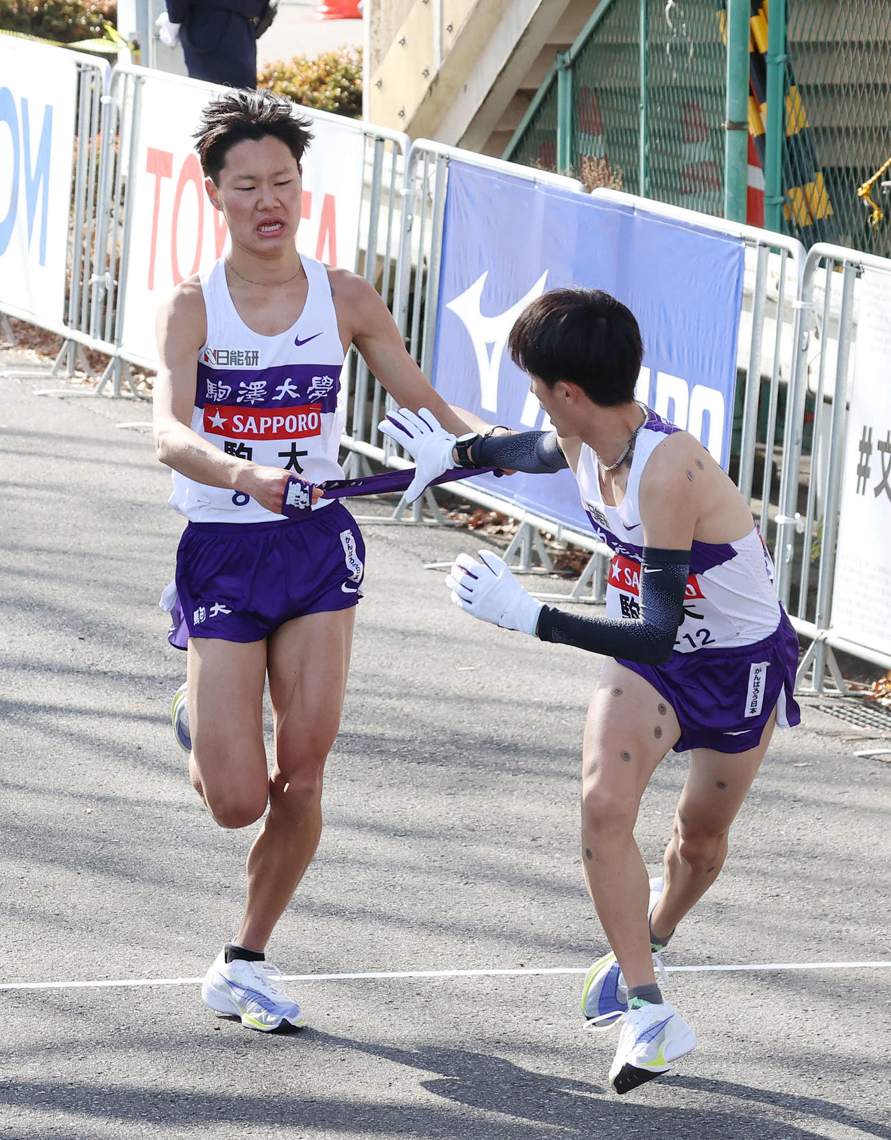 鶴見中継所、駒大10区石川（右）にタスキをつなぐ9区山野（撮影・河野匠）