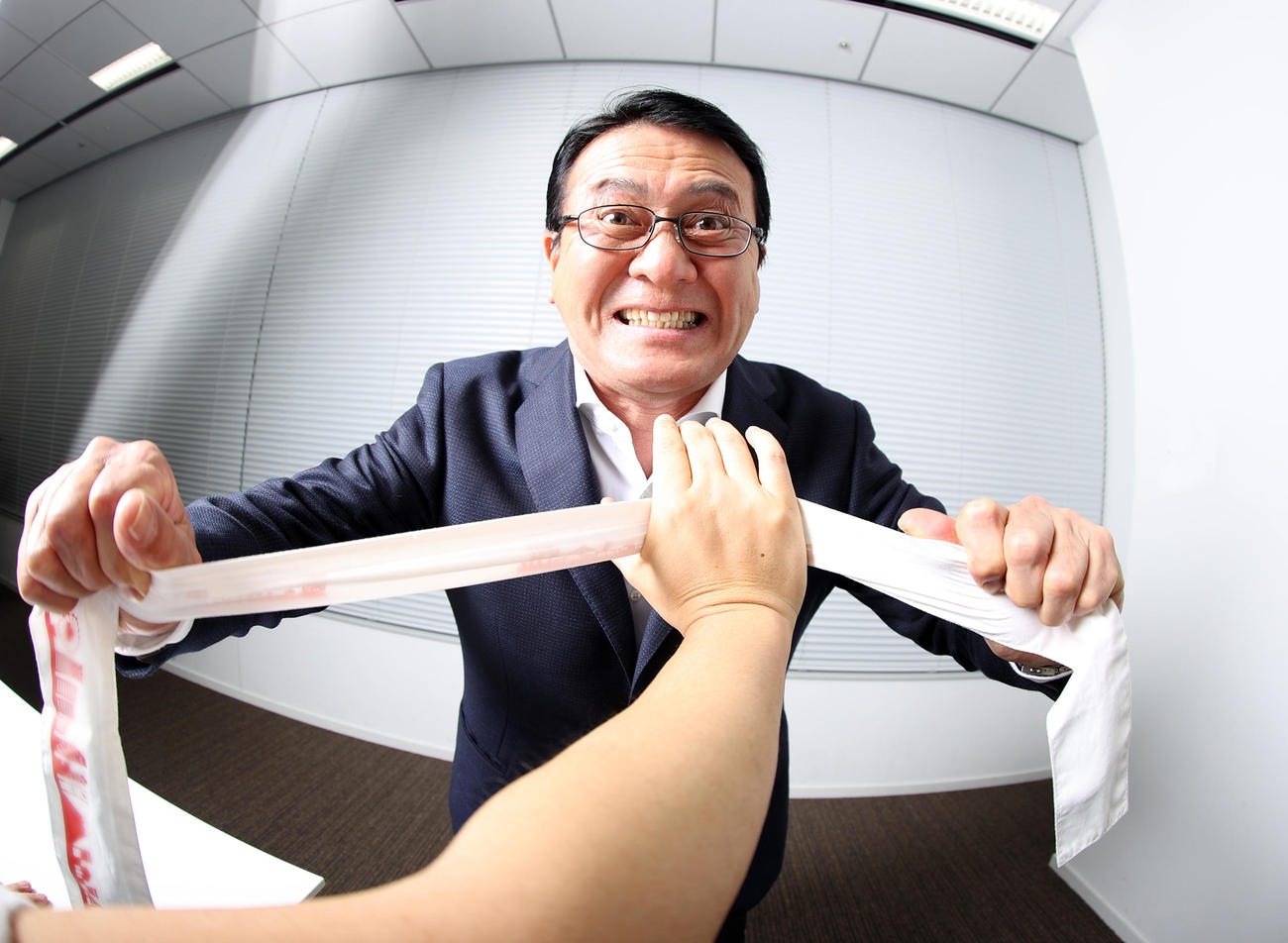 自ら記者にたすきを必死の表情で渡す日本陸連の瀬古マラソン強化戦略プロジェクトリーダー（撮影・浅見桂子）