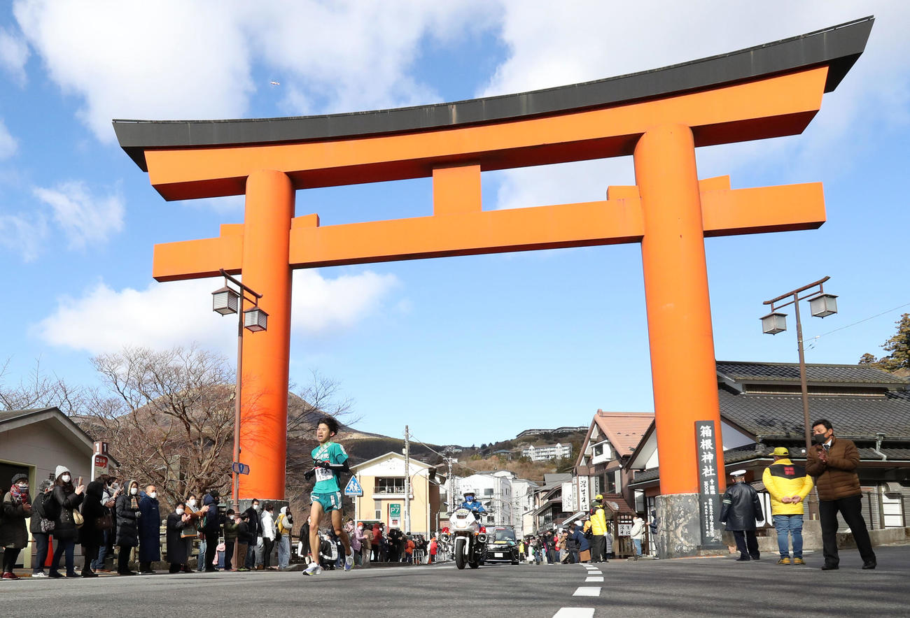 箱根神社の大鳥居を苦しそうな表情で走り抜ける青学大5区竹石（撮影・狩俣裕三）