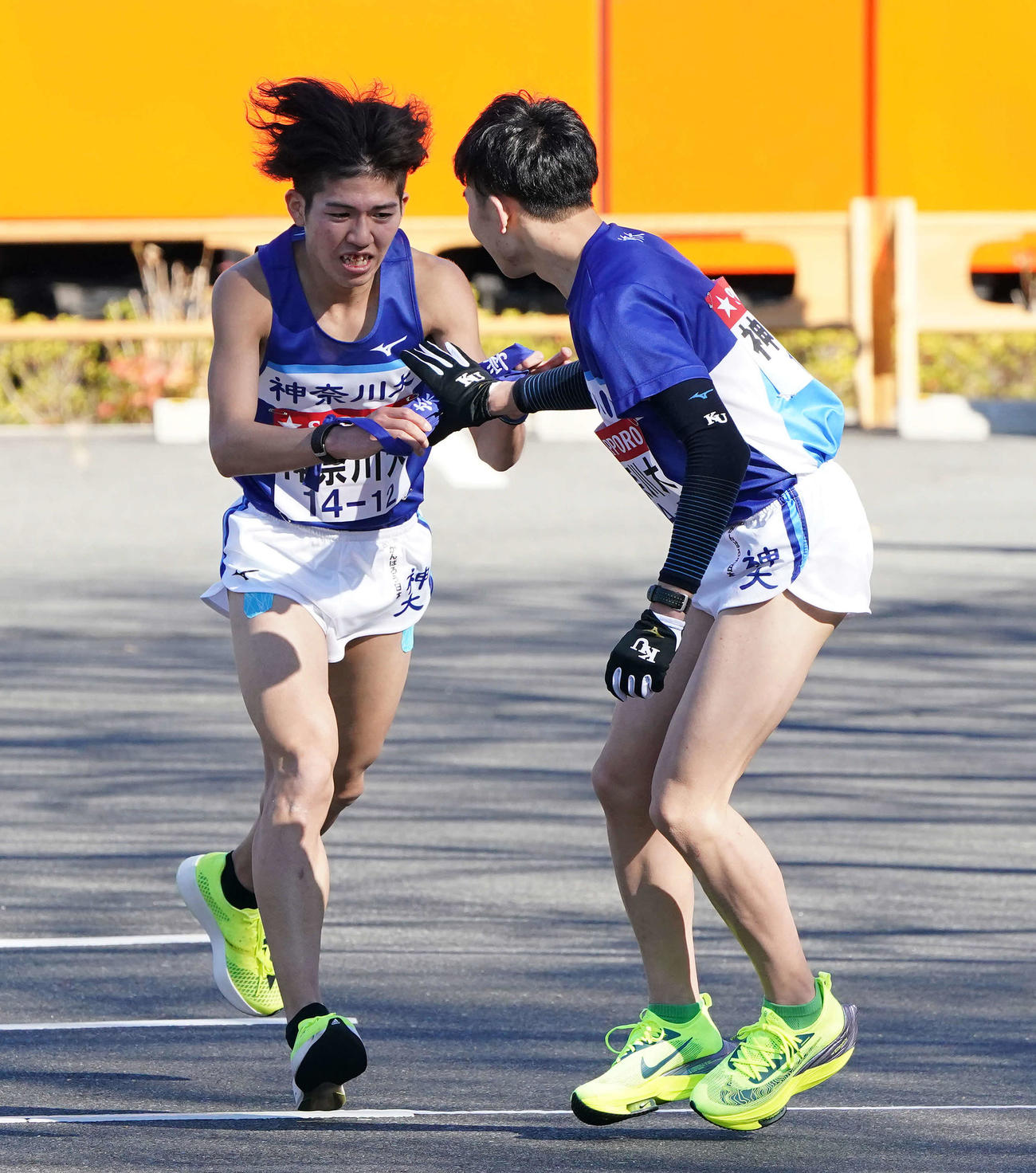 小田原中継所で5区北崎（右）にたすきを渡す神奈川大4区西方（撮影・鈴木みどり）