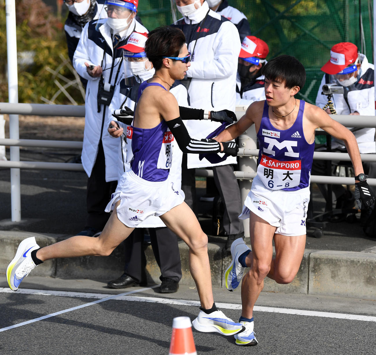 平塚中継所、タスキをつなぐ明大7区手島（左）と8区大保（撮影・横山健太）
