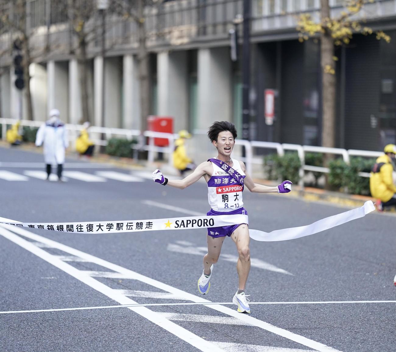 総合優勝のゴールテープを切る駒大10区石川（撮影・江口和貴）