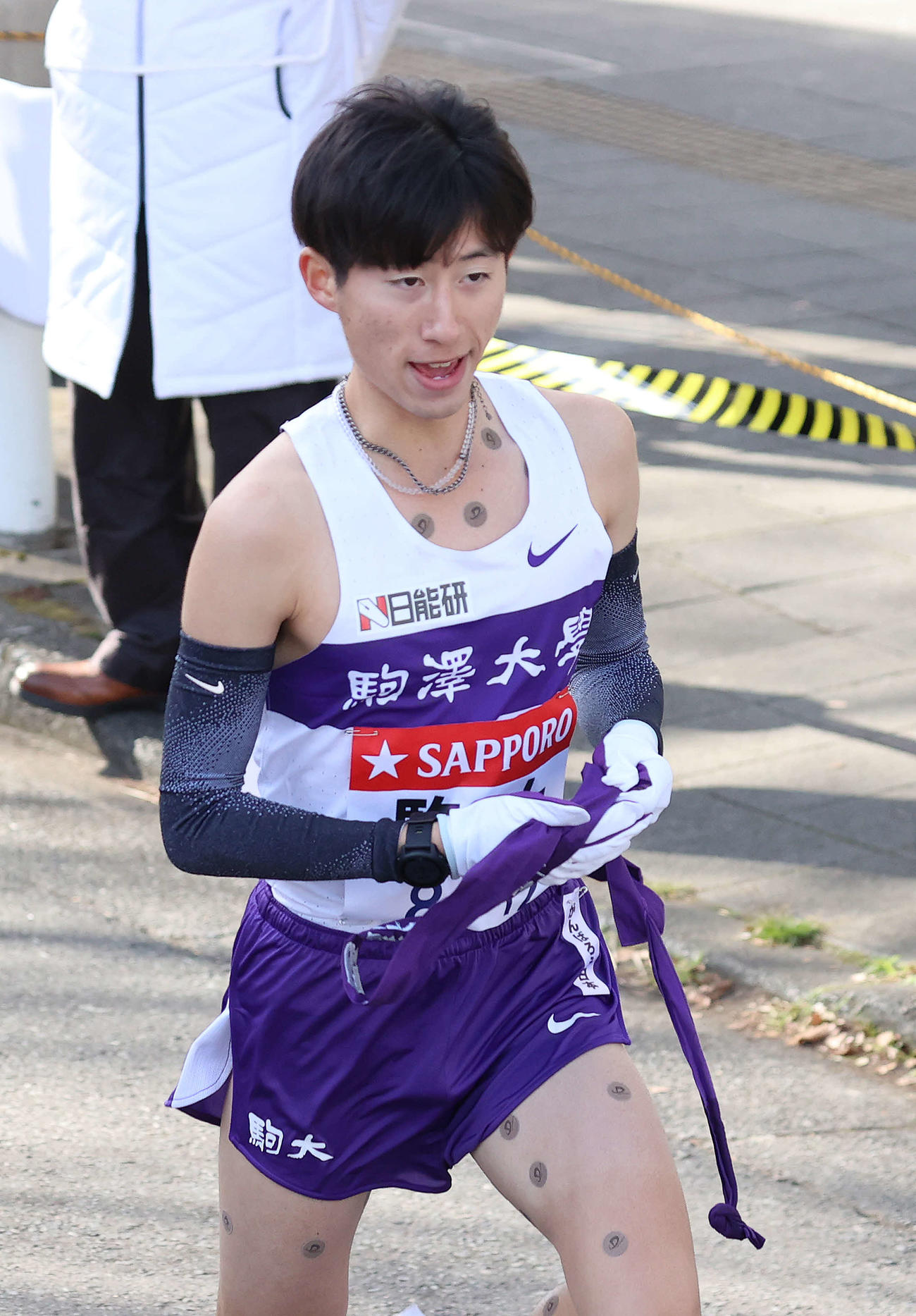 鶴見中継所、駒大9区山野からタスキを受けて駆け出す10区石川（撮影・河野匠）