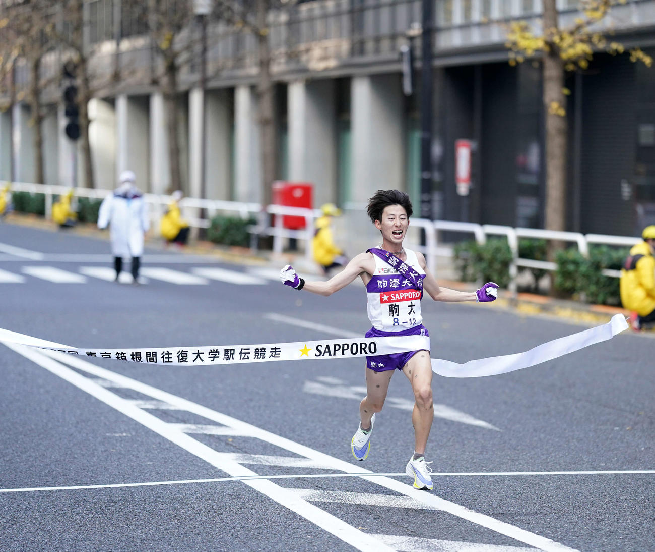 総合優勝を決めガッツポーズでゴールテープを切る駒大10区石川（撮影・江口和貴）