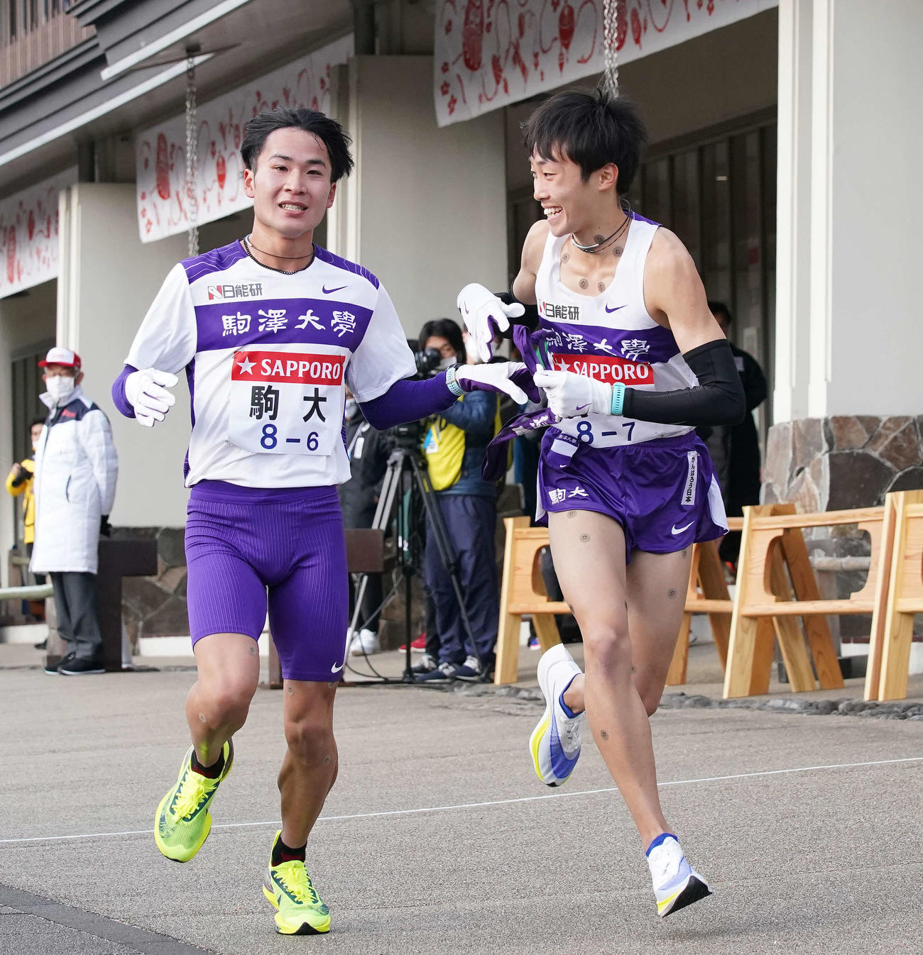 小田原中継所で7区花尾（右）にたすきを渡す駒大6区花崎（撮影・鈴木みどり）