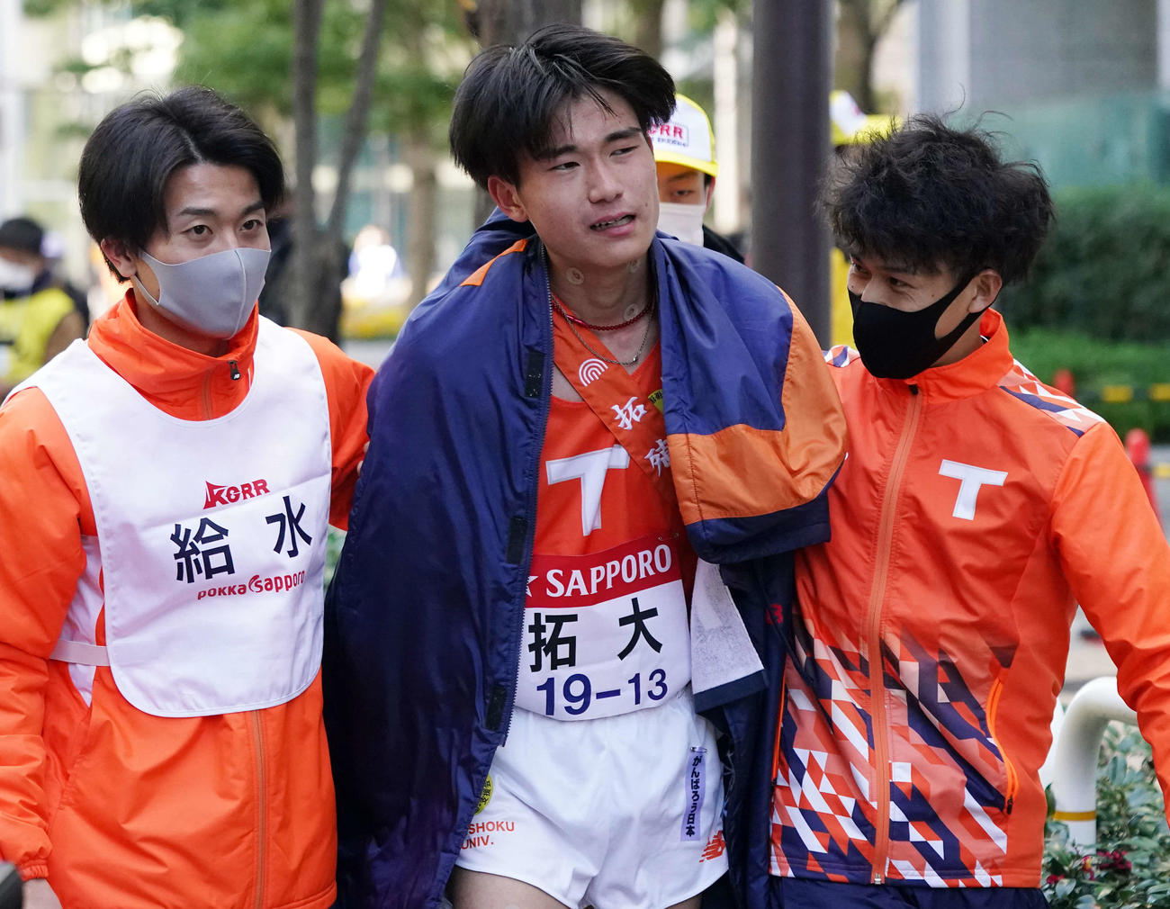 総合15位でゴールしチームメートと引き揚げる拓大10区工藤（中央）（撮影・江口和貴）