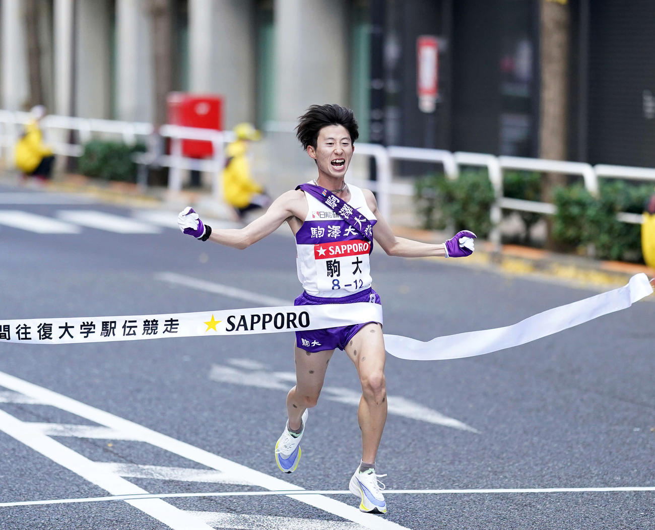 総合優勝を決めガッツポーズでゴールテープを切る駒大10区石川（撮影・江口和貴）