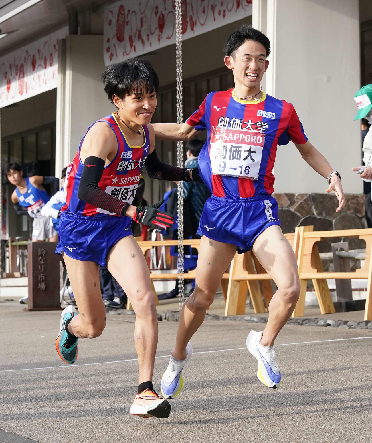 小田原中継所で7区原富（左）にトップでたすきを渡す創価大6区浜野（撮影・鈴木みどり）