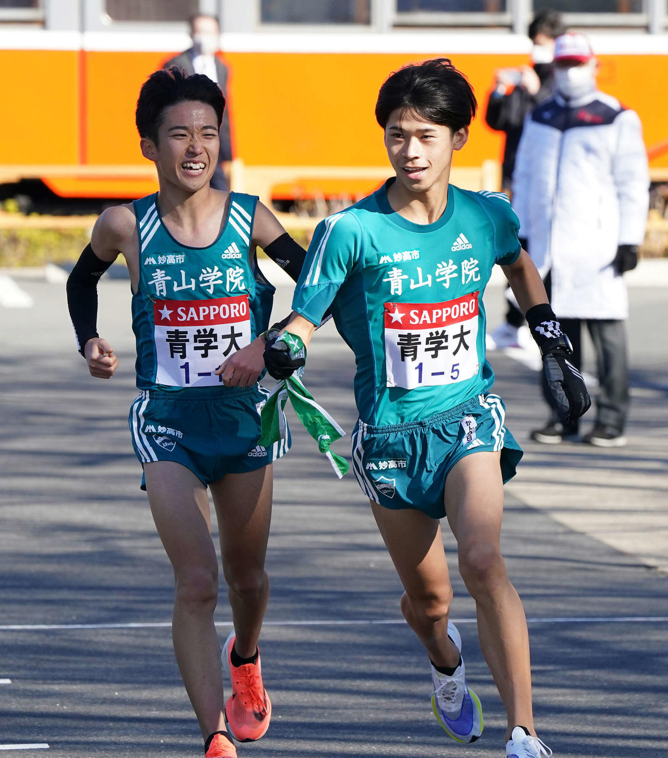 小田原中継所で5区竹石（右）にたすきを渡す青学大4区佐藤（撮影・鈴木みどり）
