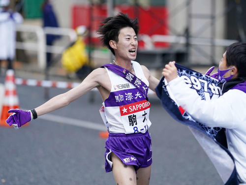 逆転優勝しチームメートに迎えられる駒大10区石川(左)(撮影・江口和貴)