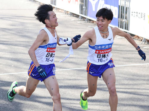 鶴見中継所、日体大10区名村樹哉(右)にタスキをつなぐ9区野上(撮影・河野匠)