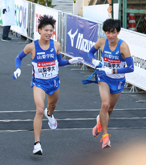 山梨学院大1区新本(左)からタスキを受けて駆け出す森山(撮影・河野匠)