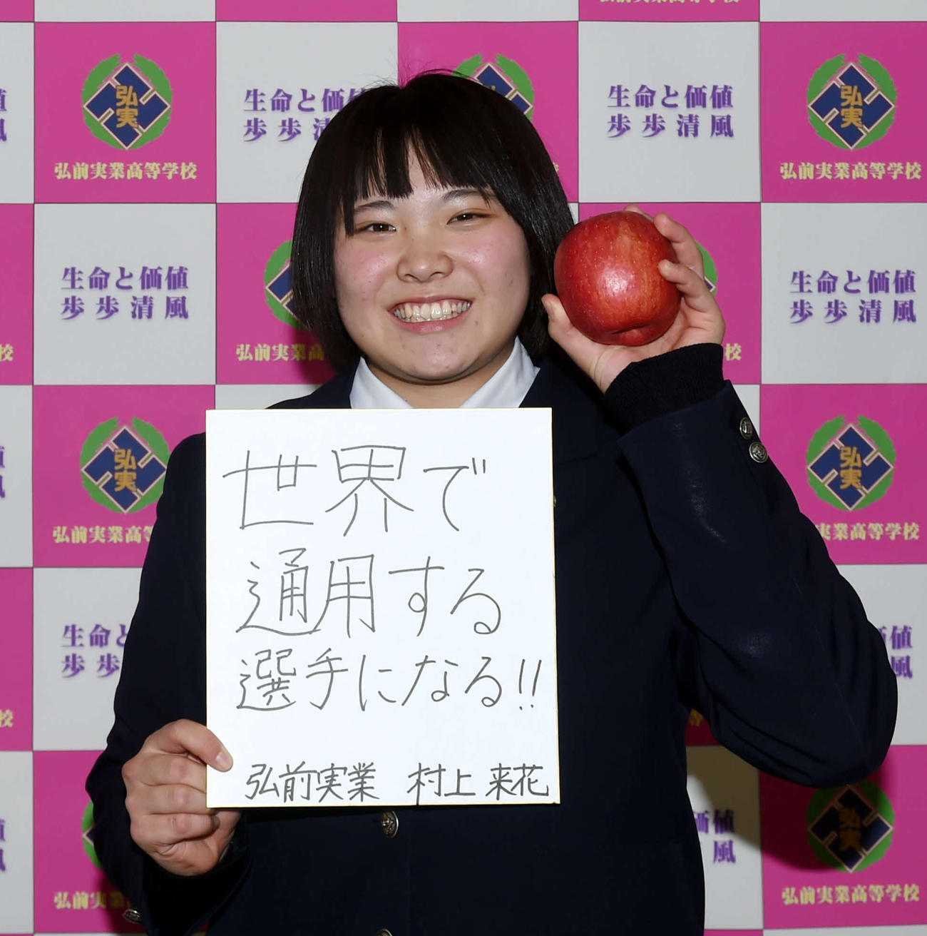 今年の目標を記した色紙と青森県名産のりんご持ちながら笑顔を見せる弘前実・村上（撮影・相沢孔志）