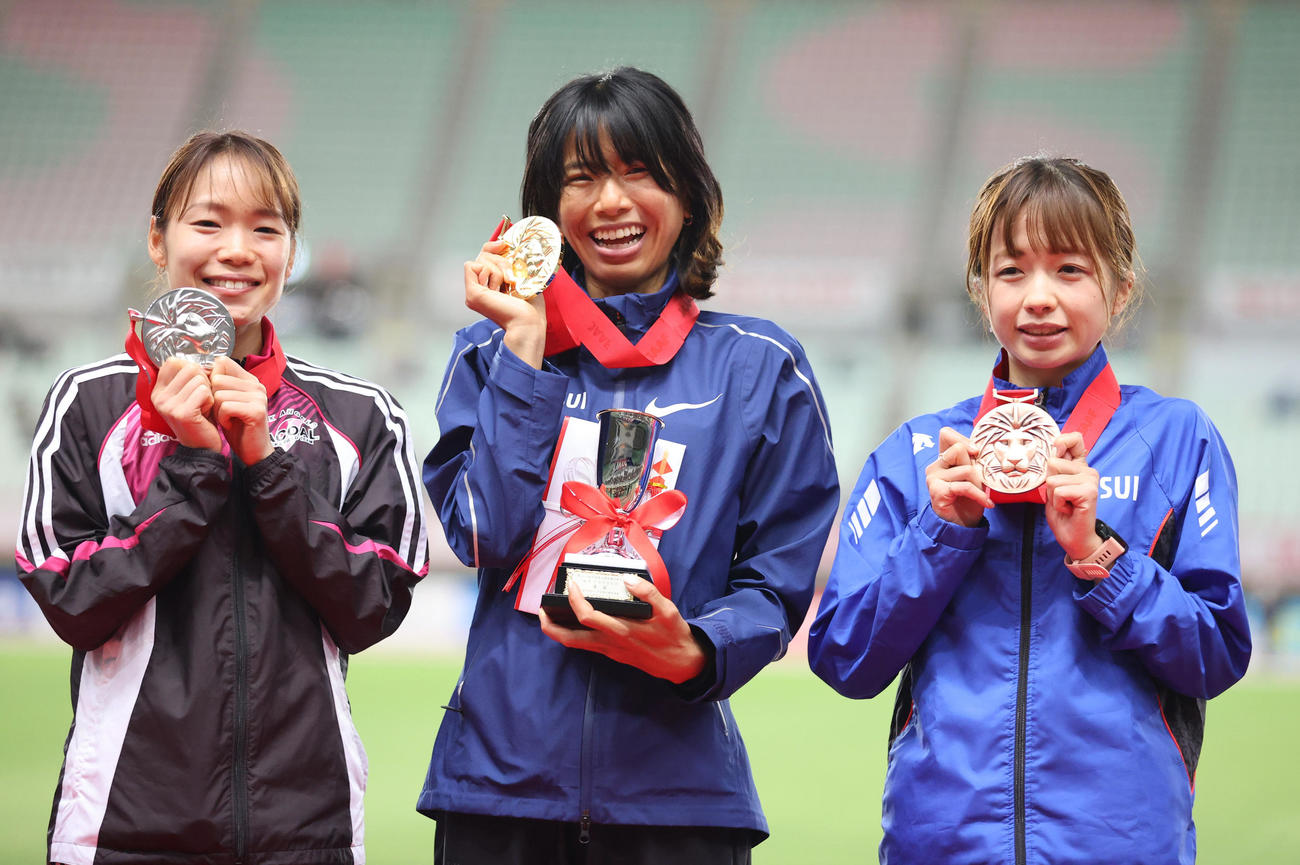 昨年12月4日、日本陸上競技選手権大会・長距離種目の女子1万メートル表彰式でメダルを掲げる3位佐藤（右）。中央は1位の新谷、左は2位の一山