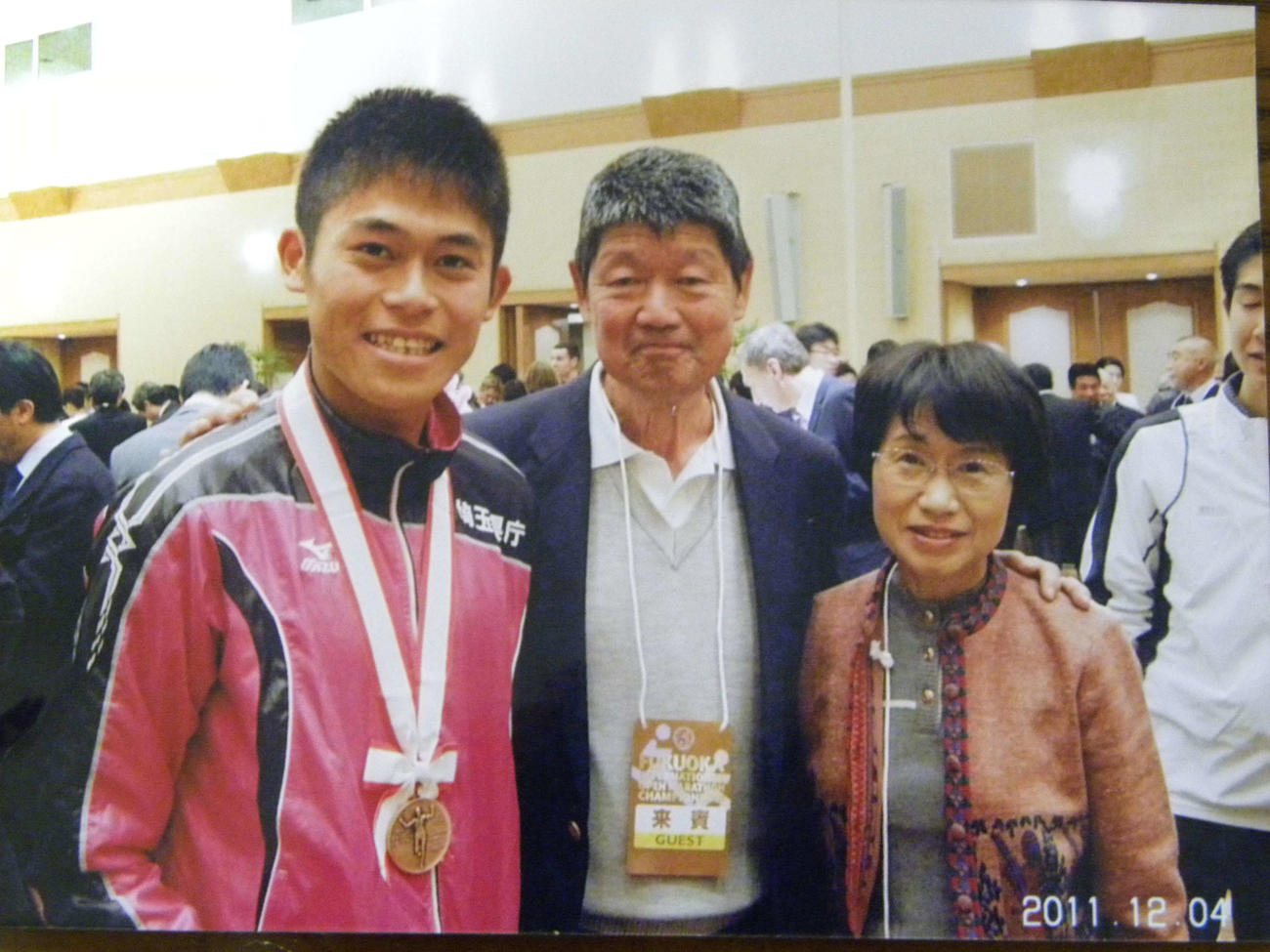 11年の福岡国際マラソン時に写真に納まる、左から川内優輝、采谷義秋さん、妻の宣子さん（采谷家提供）