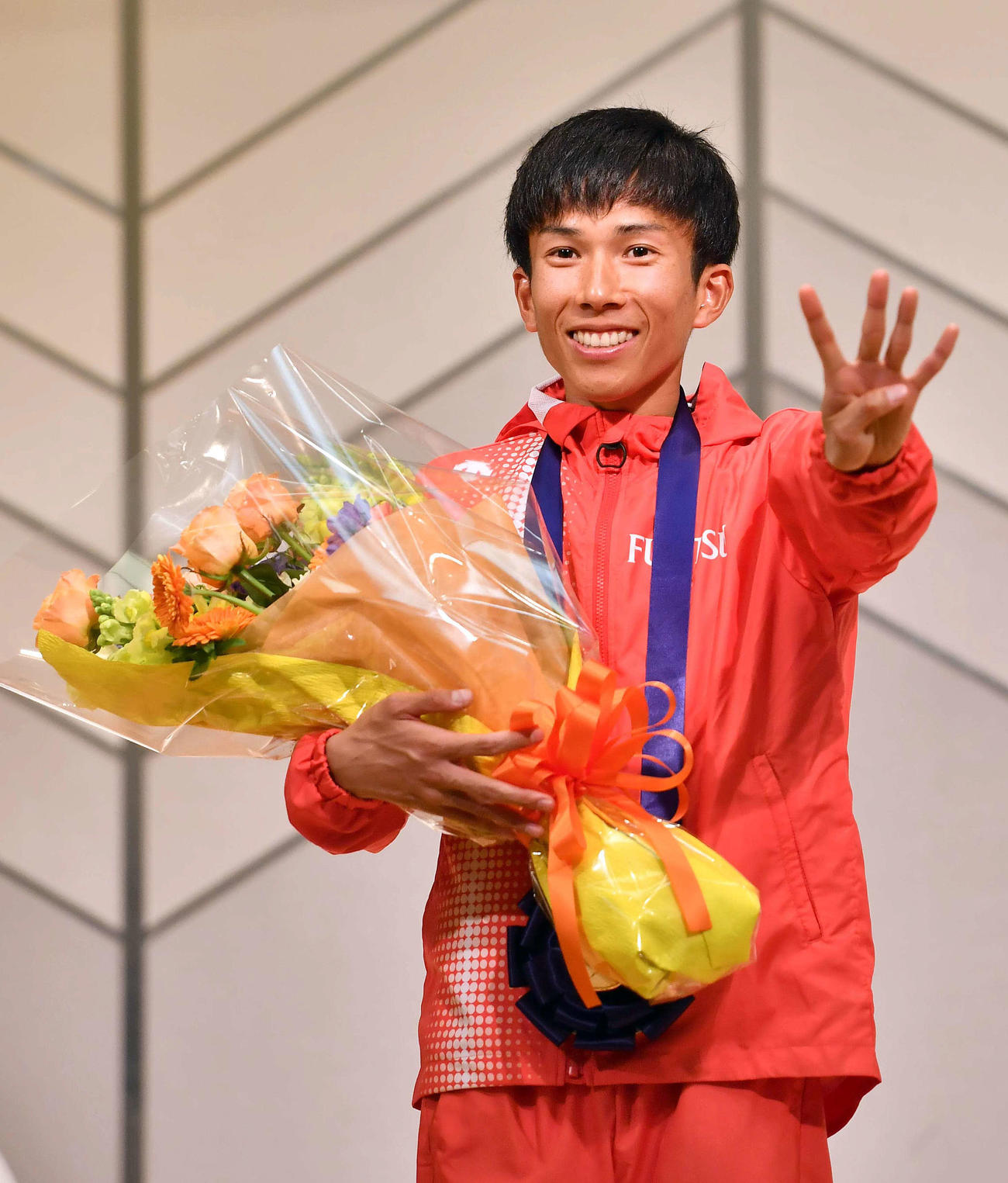 2時間4分56秒の日本人初の4分台で優勝した鈴木はアワードセレモニーに参加し4のポーズで笑顔を見せる（撮影・上田博志）