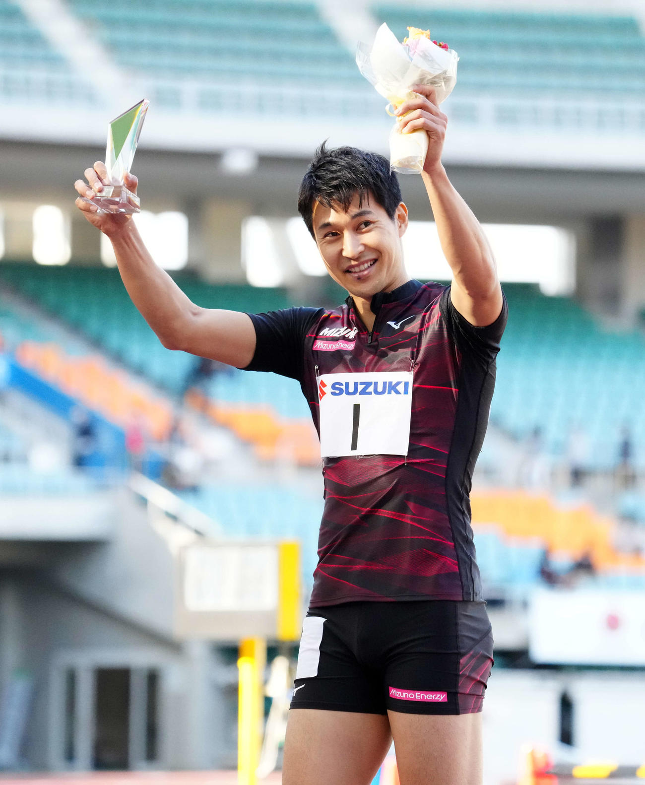 男子200メートルで優勝しスタンドに向かって手を上げる飯塚（撮影・江口和貴）