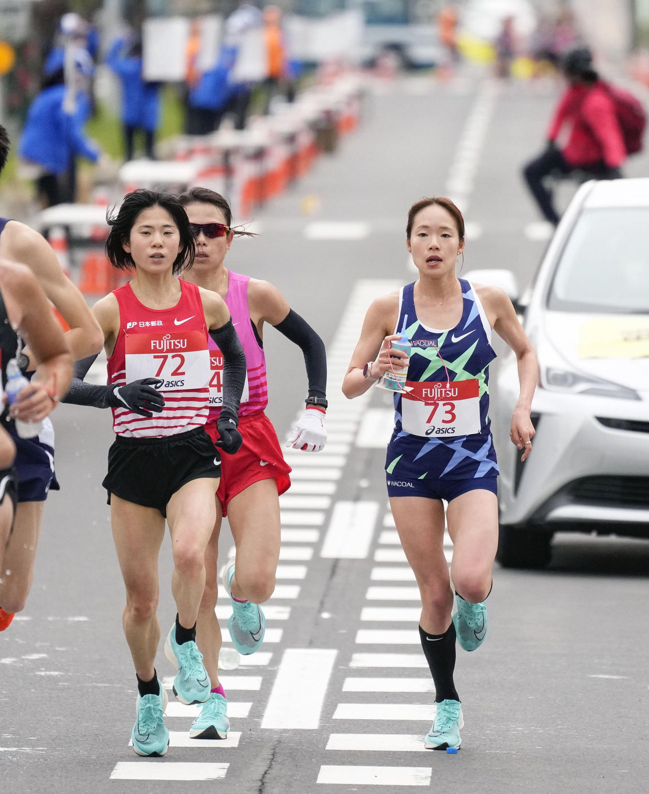 女子ハーフマラソン　レース中盤で、ドリンクを手に力走する一山麻緒（右）。左手前は鈴木亜由子（共同）