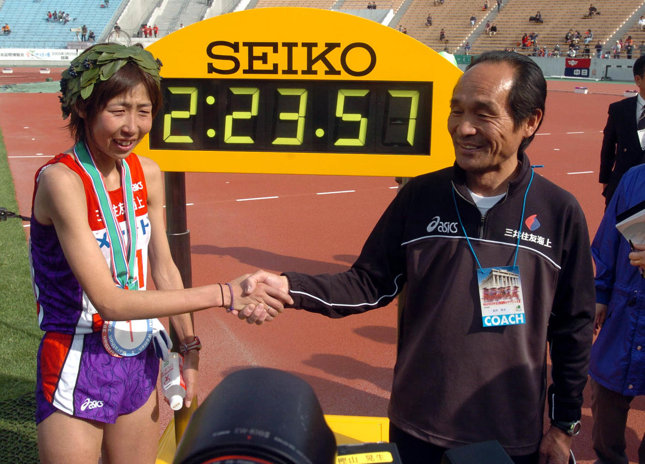 2時間23分57秒で優勝した土佐礼子は鈴木秀夫監督（右）と時計の前で握手