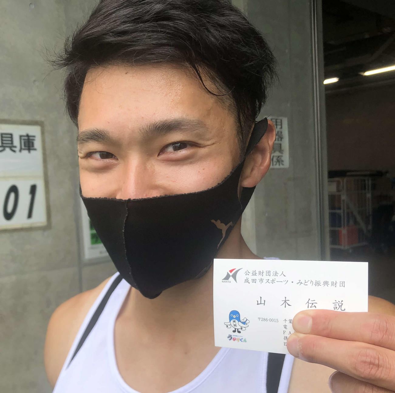 記者のリクエストに応じ、自身の名刺を持つ男子400メートルを制した山木伝説