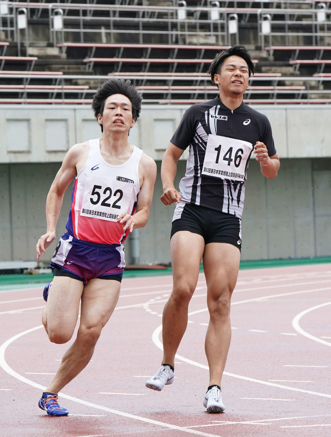 男子200メートル予選、右ふくらはぎを痛めてレースをやめる白石（右）。左は相良（撮影・河野匠）