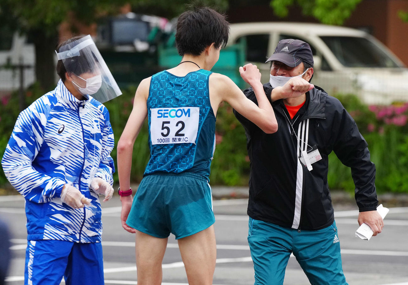 関東学生対校選手権の男子2部ハーフマラソンで優勝した青学大・西久保（中央）とタッチをかわす原監督（右）（撮影・江口和貴）