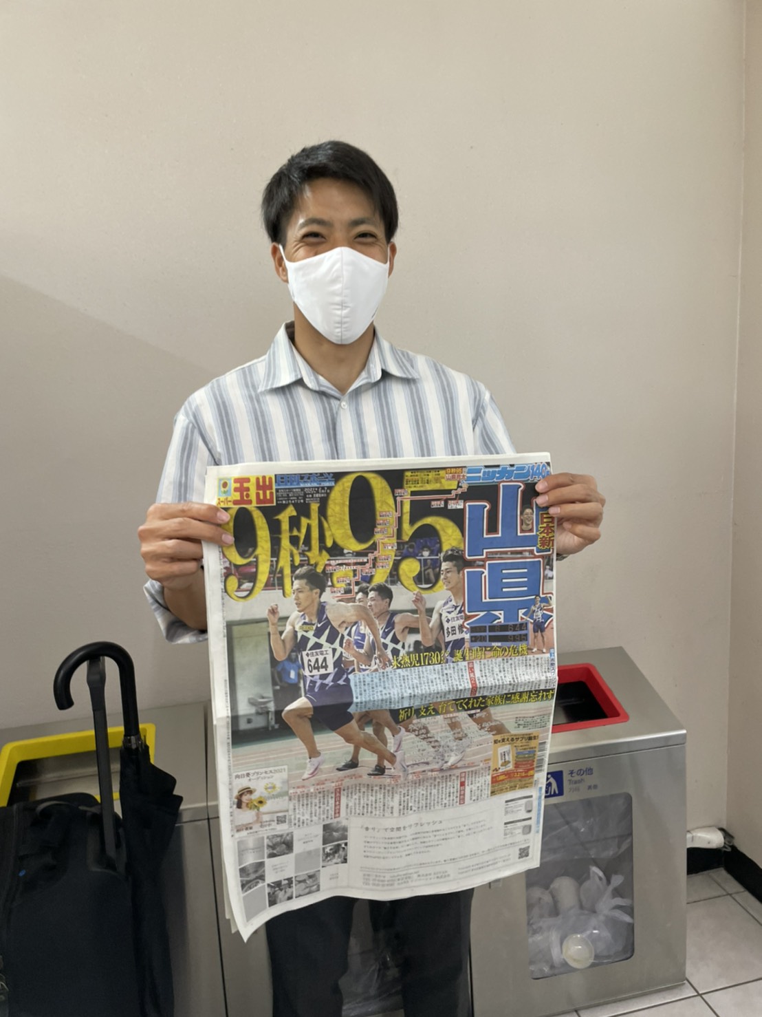 自身の日本新を1面で伝える6月7日付の日刊スポーツを持ち、笑顔の山県